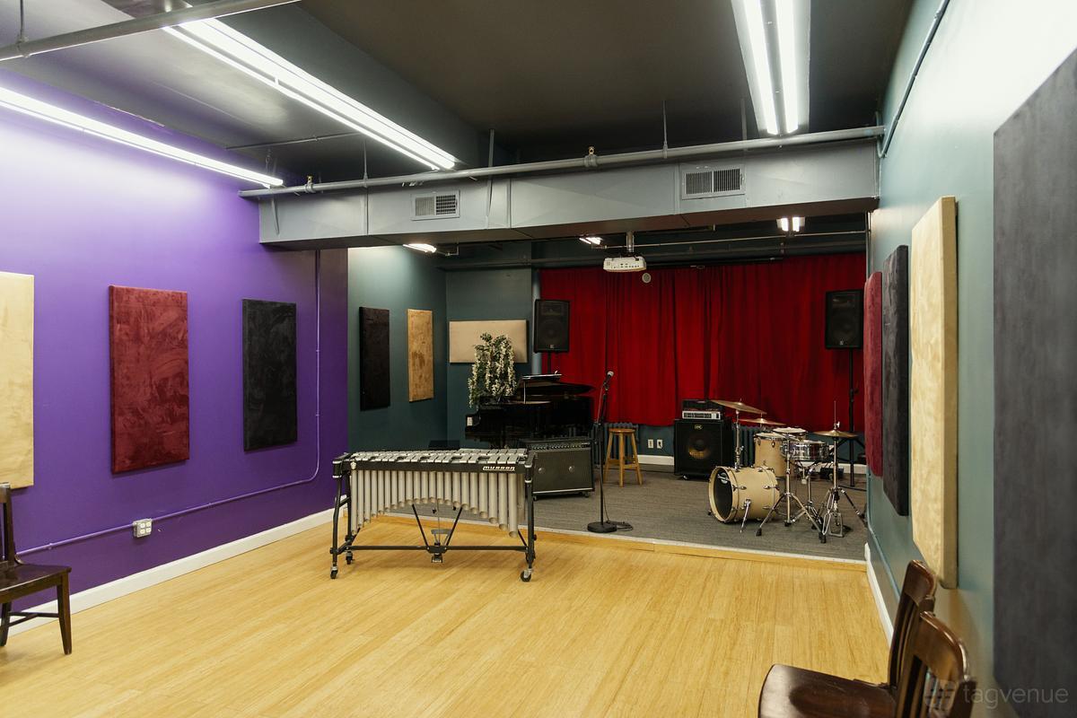 An event venue in a rehearsal studio with a piano, drum set, vibraphone, and colorful acoustic panels at Michiko Rehearsal Studios.