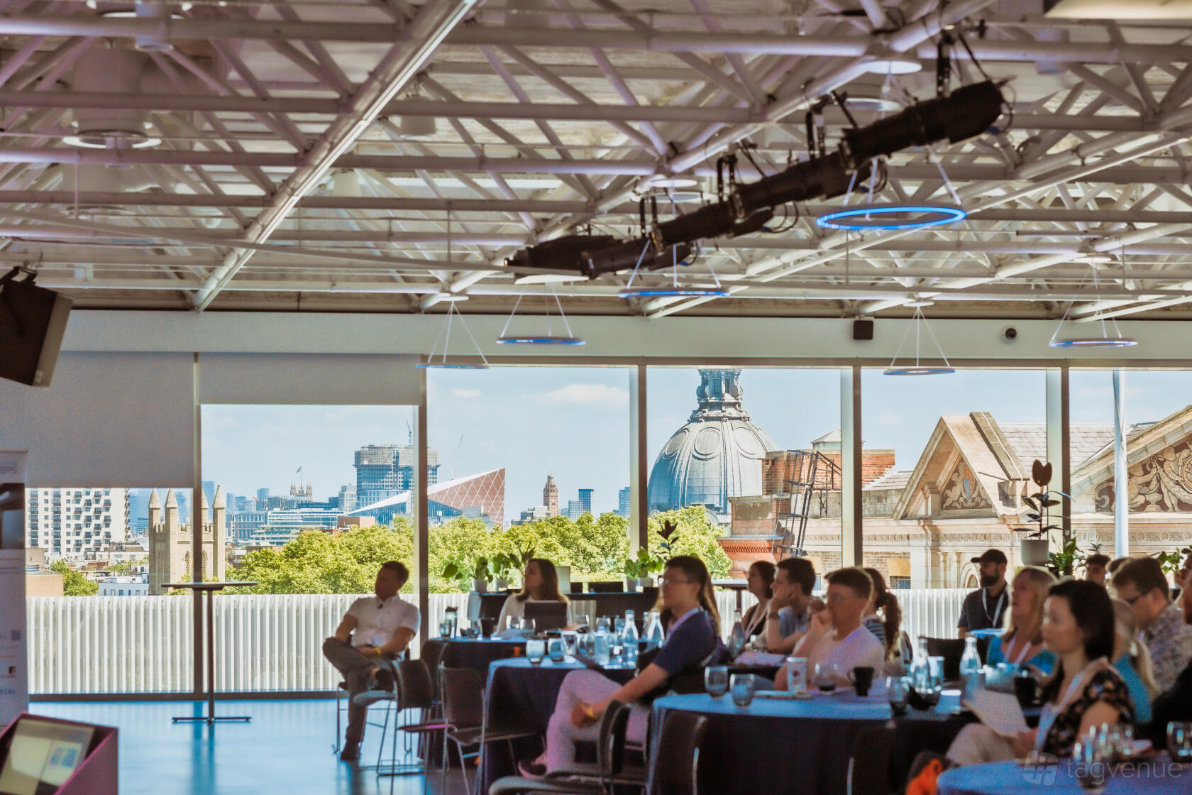 An event space in a museum with floor-to-ceiling windows, exposed ceiling beams, and city skyline views at Science Museum.