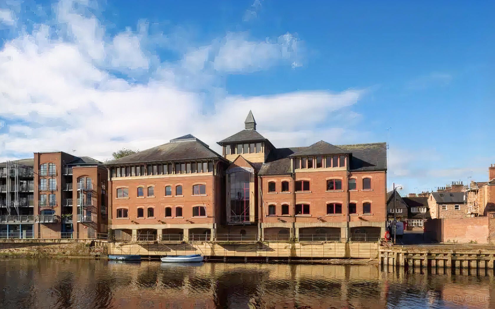 A brick coworking space with large arched windows and a riverside location at Wizu Workspace - East Coast House.