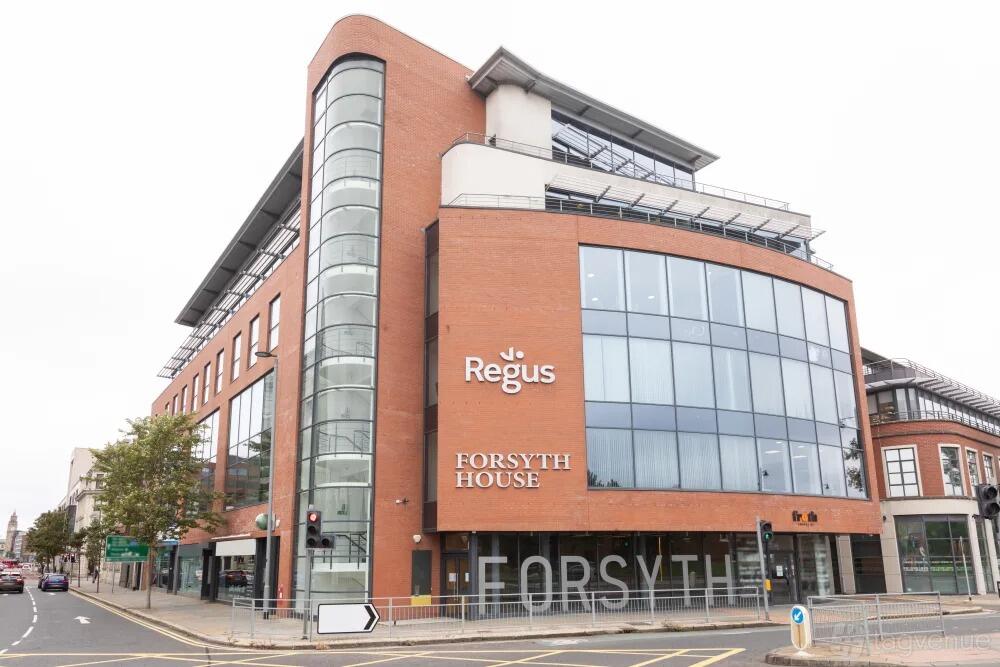 A glass-fronted business center with curved corner windows and brick facade at Regus – Belfast City Centre.