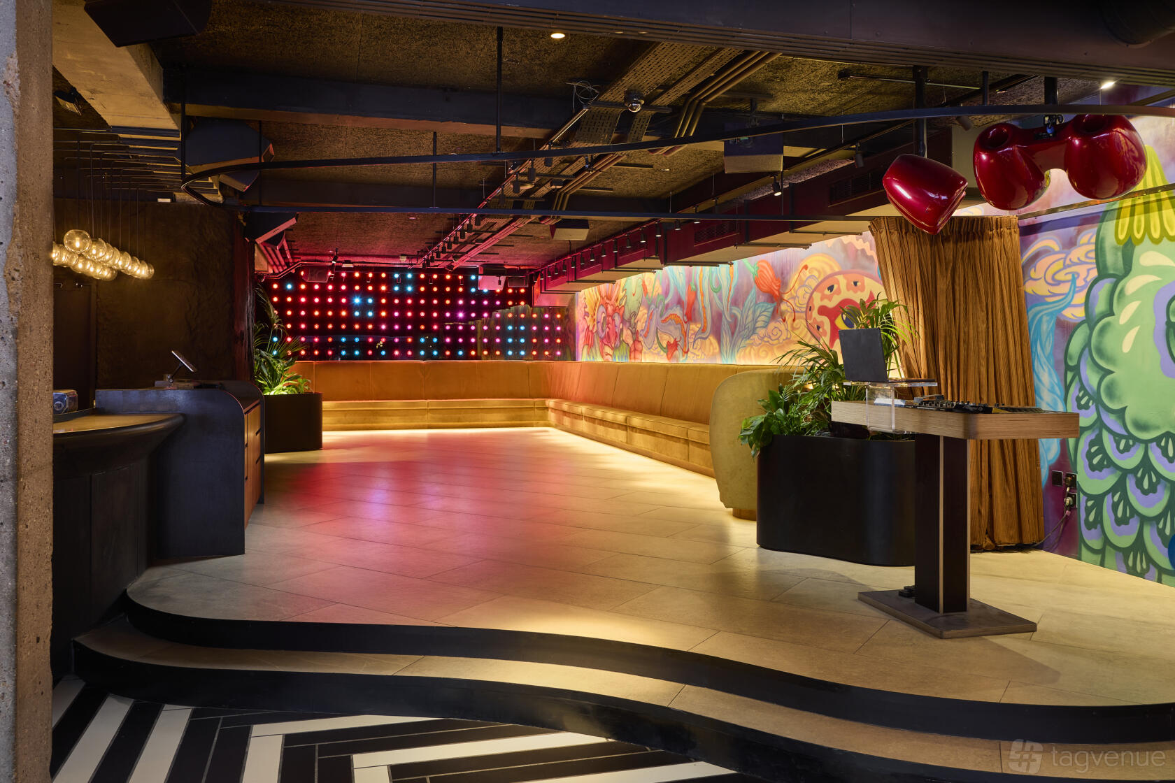 An event space in a restaurant with colorful graffiti walls, ambient lighting, and a geometric tile floor at Chotto Matte.