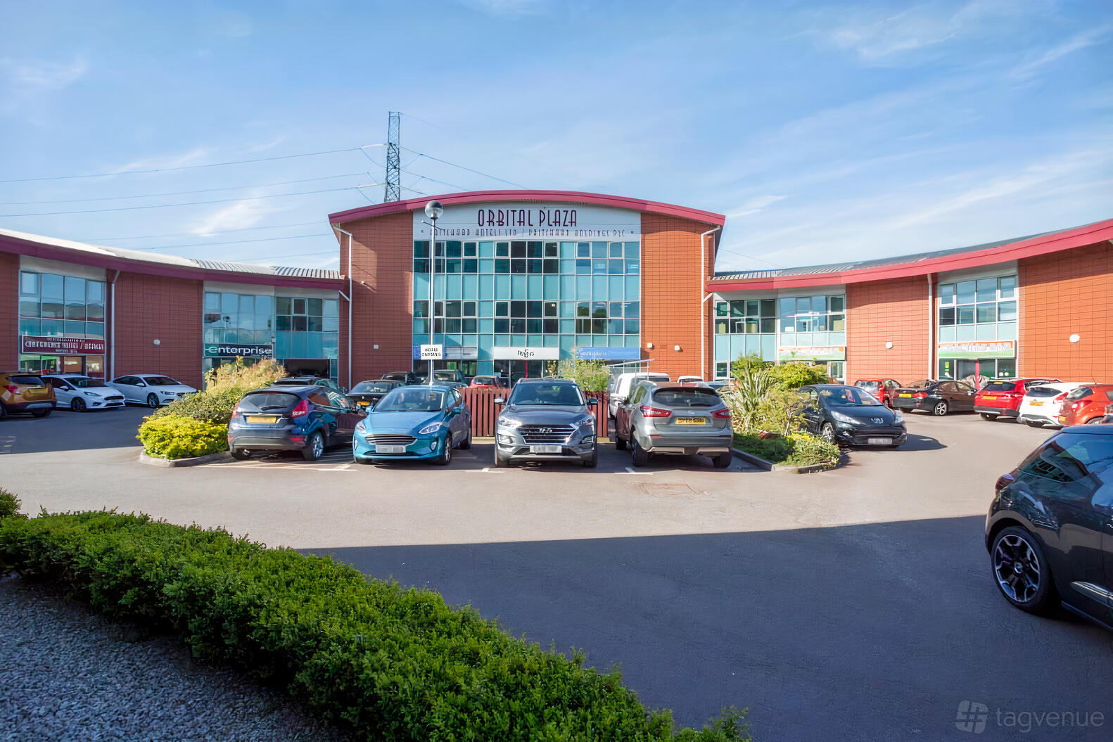 A meeting centre with a brick facade, large glass windows, and a parking lot at Regus - Birmingham, Cannock.