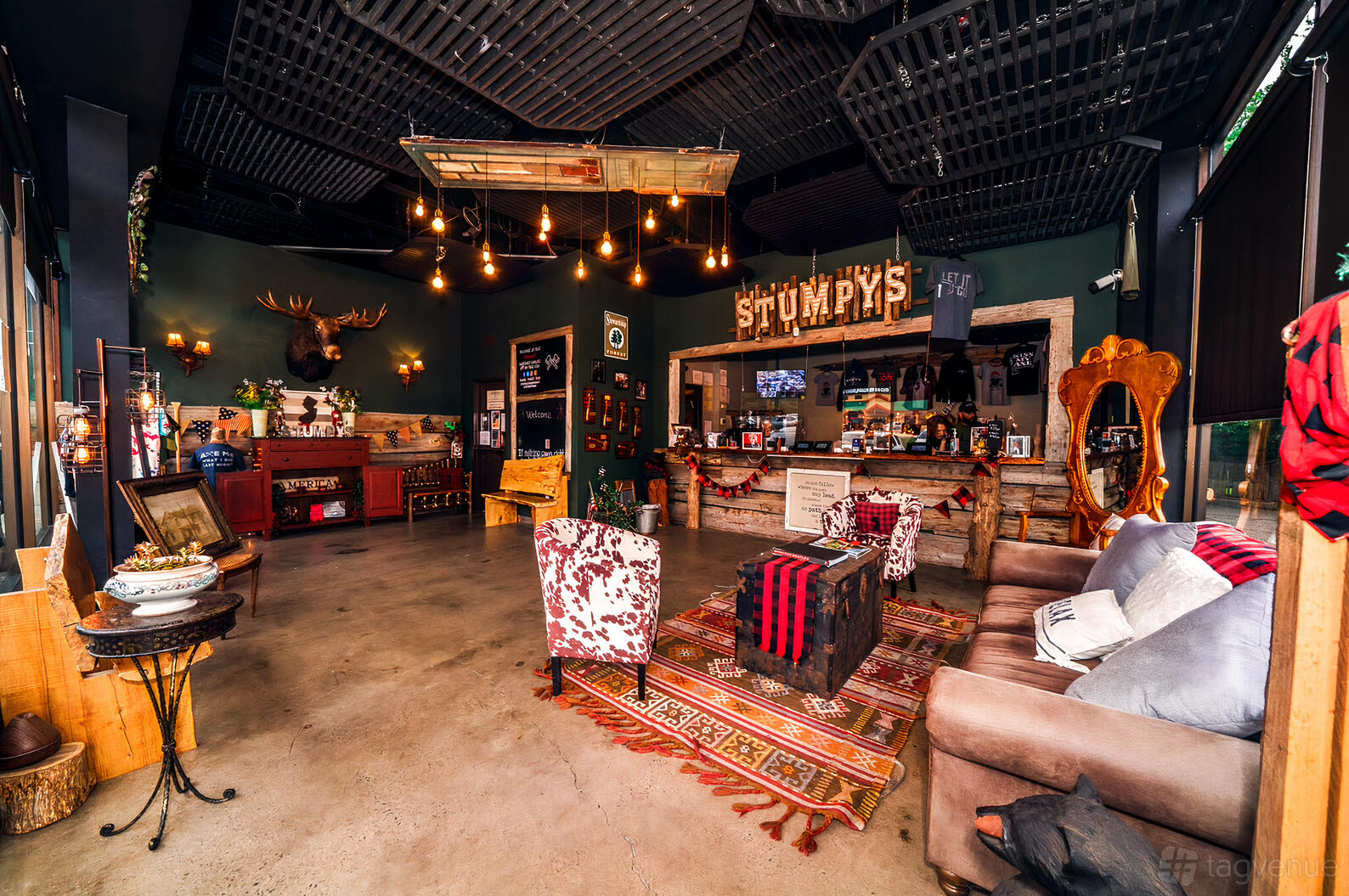 An event venue with eclectic lounge seating, vintage decor, and a rustic wooden bar at Stumpy’s Hatchet House - Green Brook NJ.