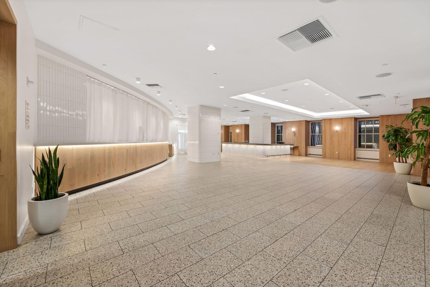 An event venue with tiled flooring, wood-paneled walls, and potted plants at EQX City Catering & Events.