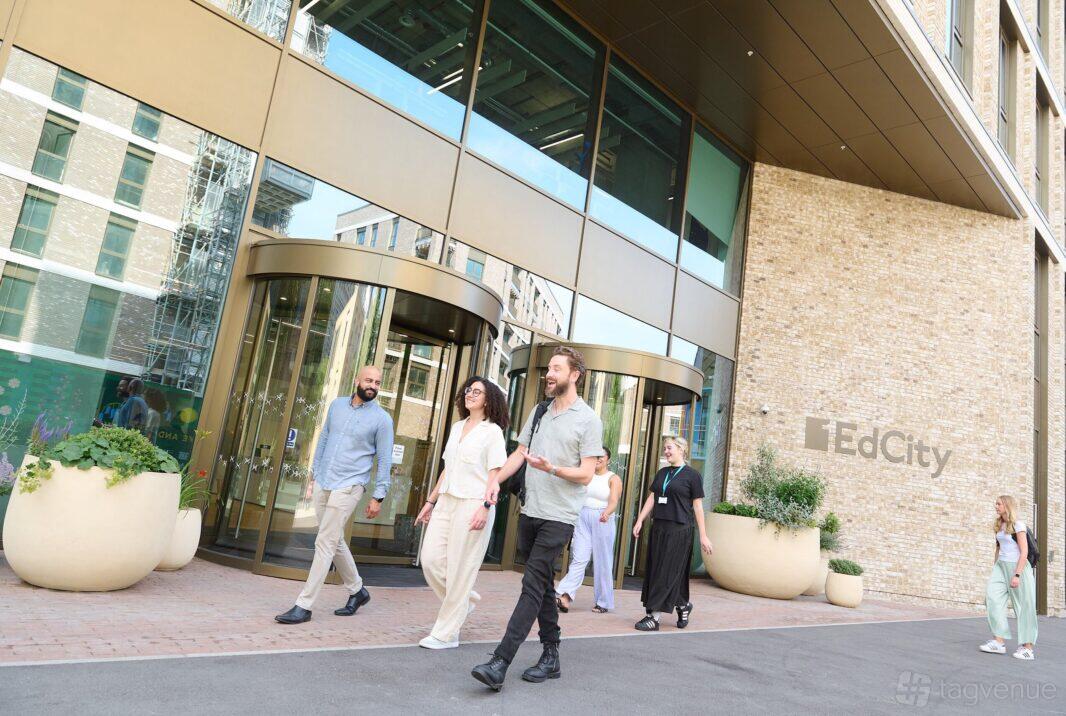 A meeting centre entrance with glass revolving doors and large planters at EdCity.