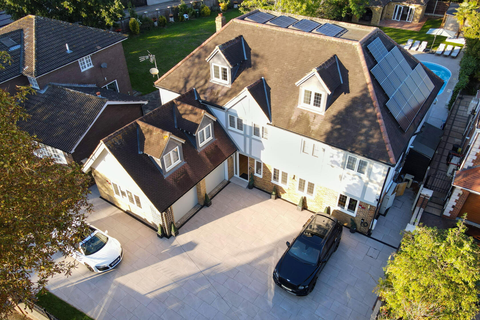 A versatile event space featuring a large villa with solar panels, paved driveway, and outdoor garden at Emerson Park Villa.