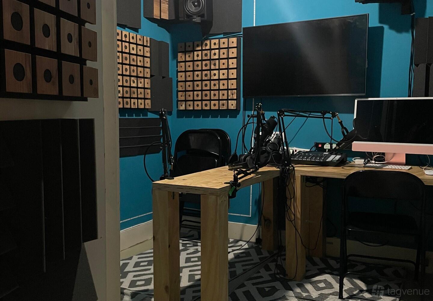 A podcast studio with soundproof panels, recording microphones, and dual monitors at Trowbridge Talks - Podcast Studio.