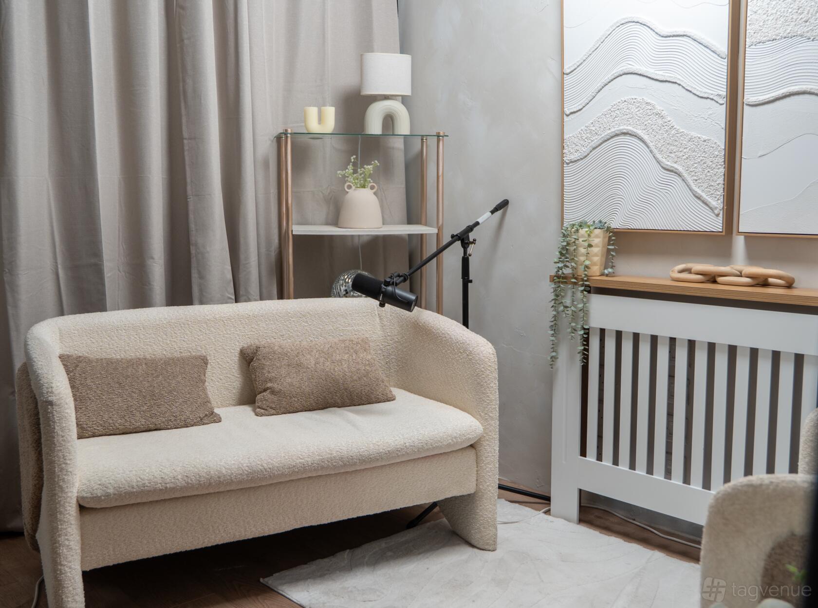 PodHaus Birmingham podcast room with cream sofa, microphone and acoustic wall decor