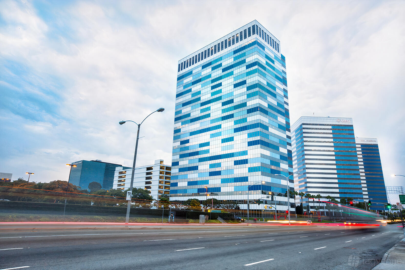 An office tower with blue and white glass windows and adjacent high-rise buildings at Premier Workspaces - El Segundo.