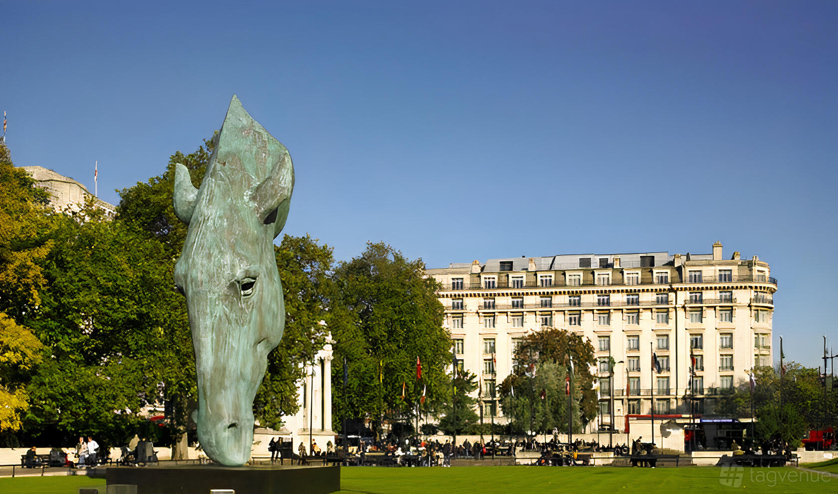 A hotel with a prominent stone facade and a large horse head sculpture on the lawn at InterContinental London Park Lane.