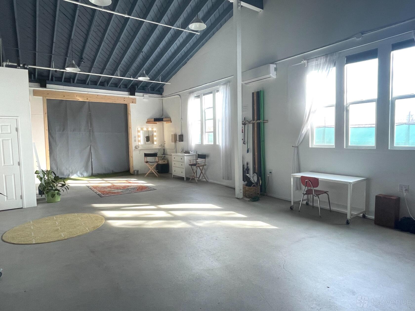 A photo studio with high ceilings, large windows for natural light, and a vanity area at 270 Studios.