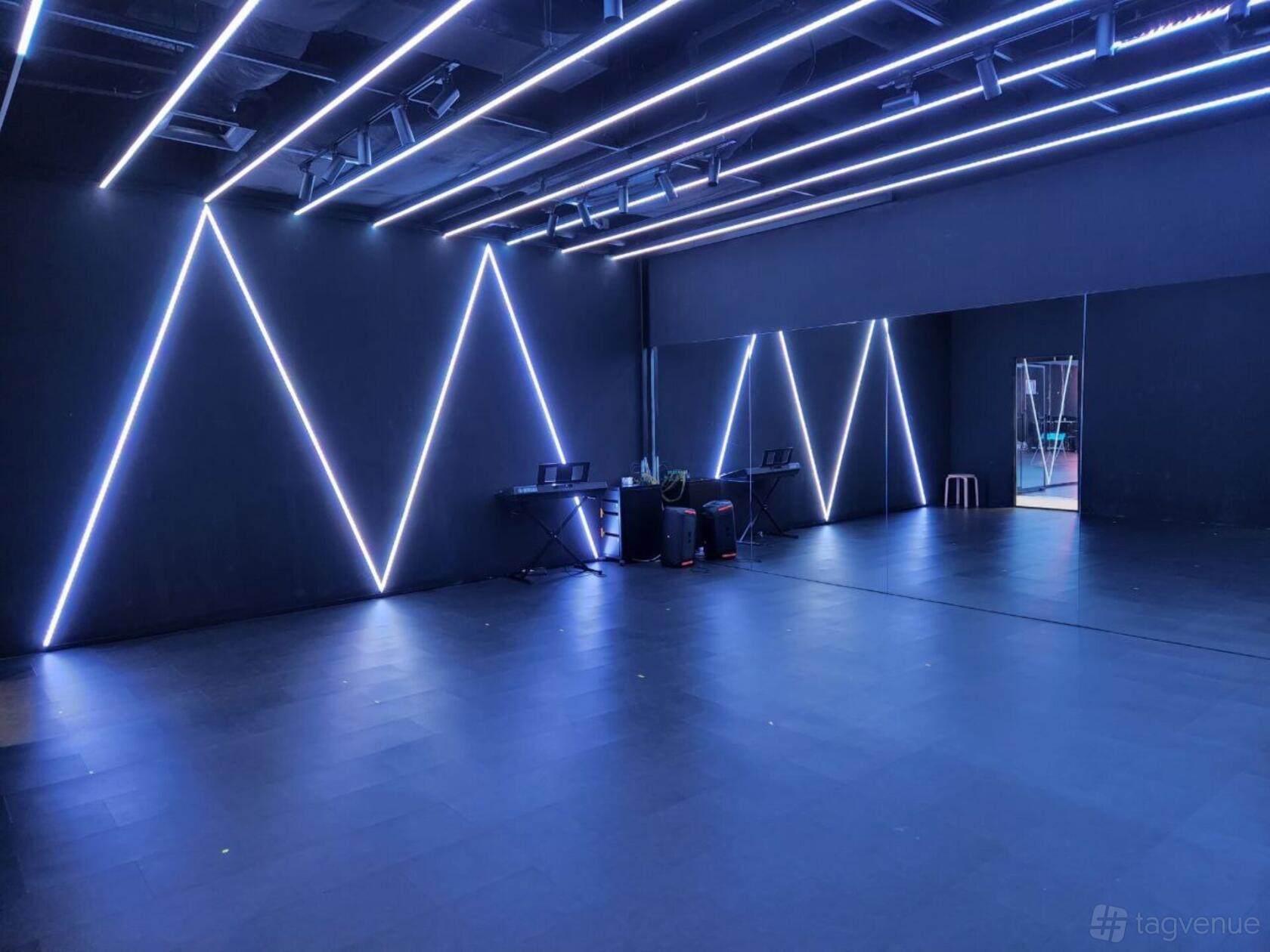A dance studio with geometric LED wall lights, mirrored walls, and a sound system at MADDspace Central @ Dhoby Ghaut.