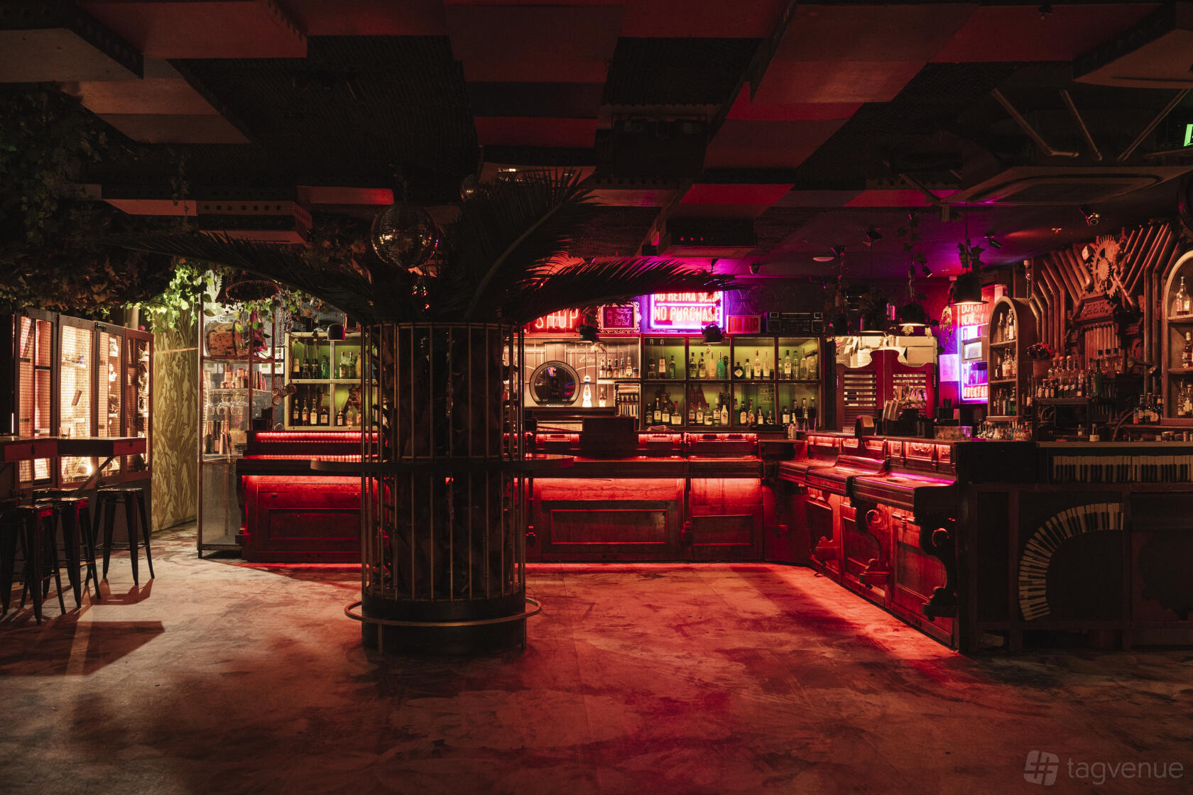 An event space in a bar with neon lighting, vintage decor, and a long wooden bar at Pawn & Co.