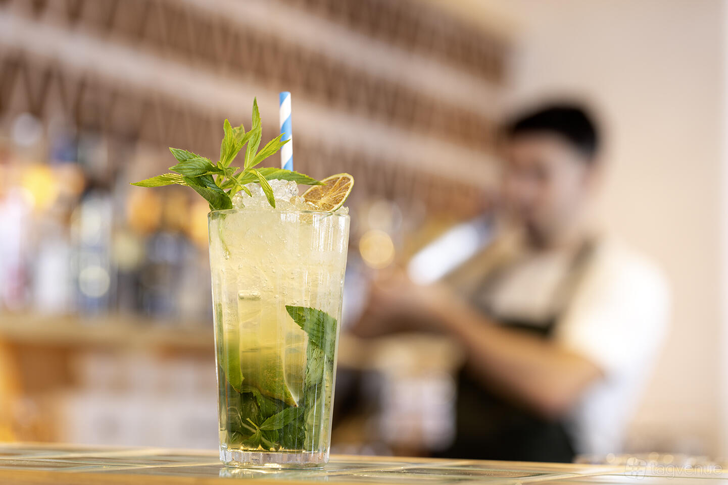 A lounge bar with a mojito cocktail garnished with mint and lime on a counter at Georges Mediterranean Restaurant.