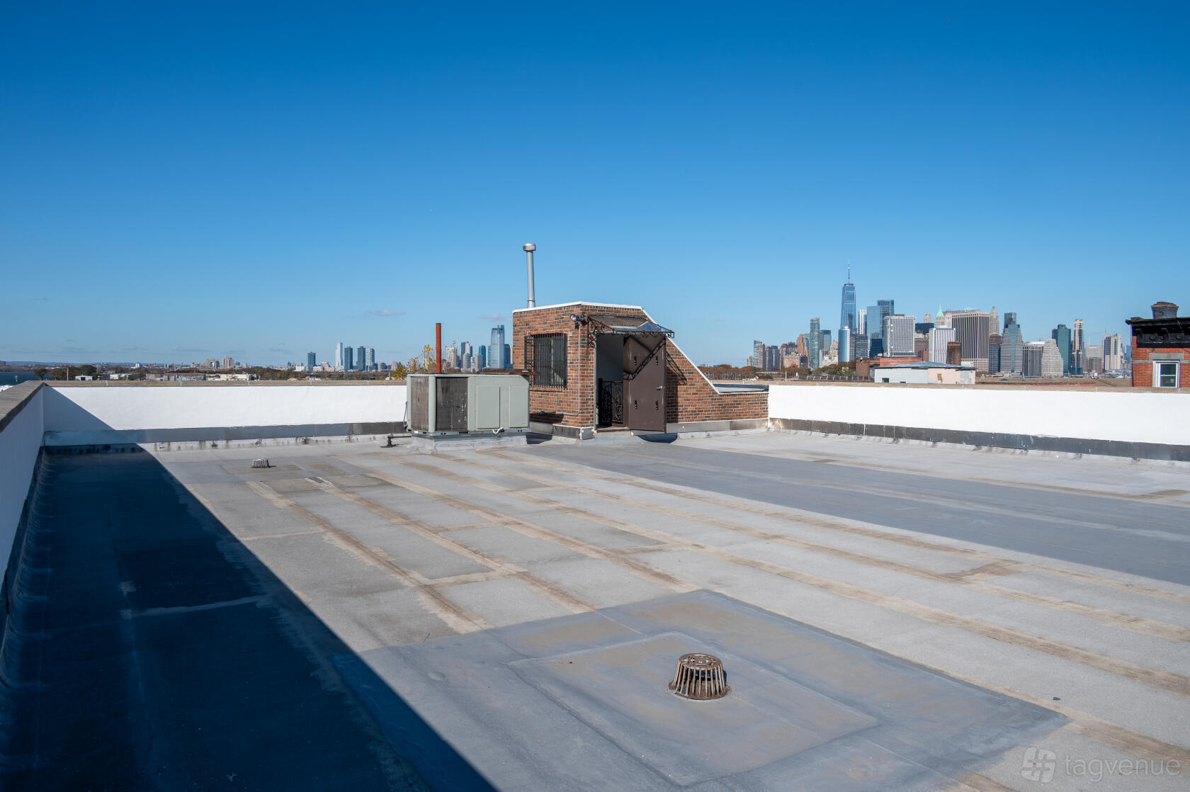 A rooftop photo studio with city skyline views and a small brick stairwell at HOOK Studios
