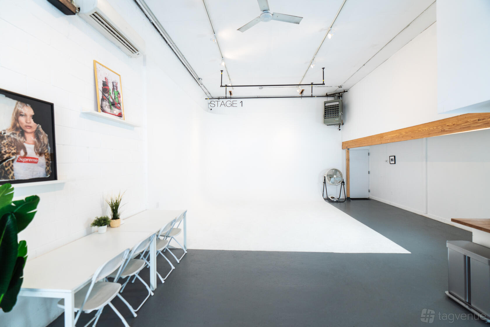 A photo studio with a white cyclorama wall, high ceiling, and a row of white chairs at HAPPYMONDAY Studio.