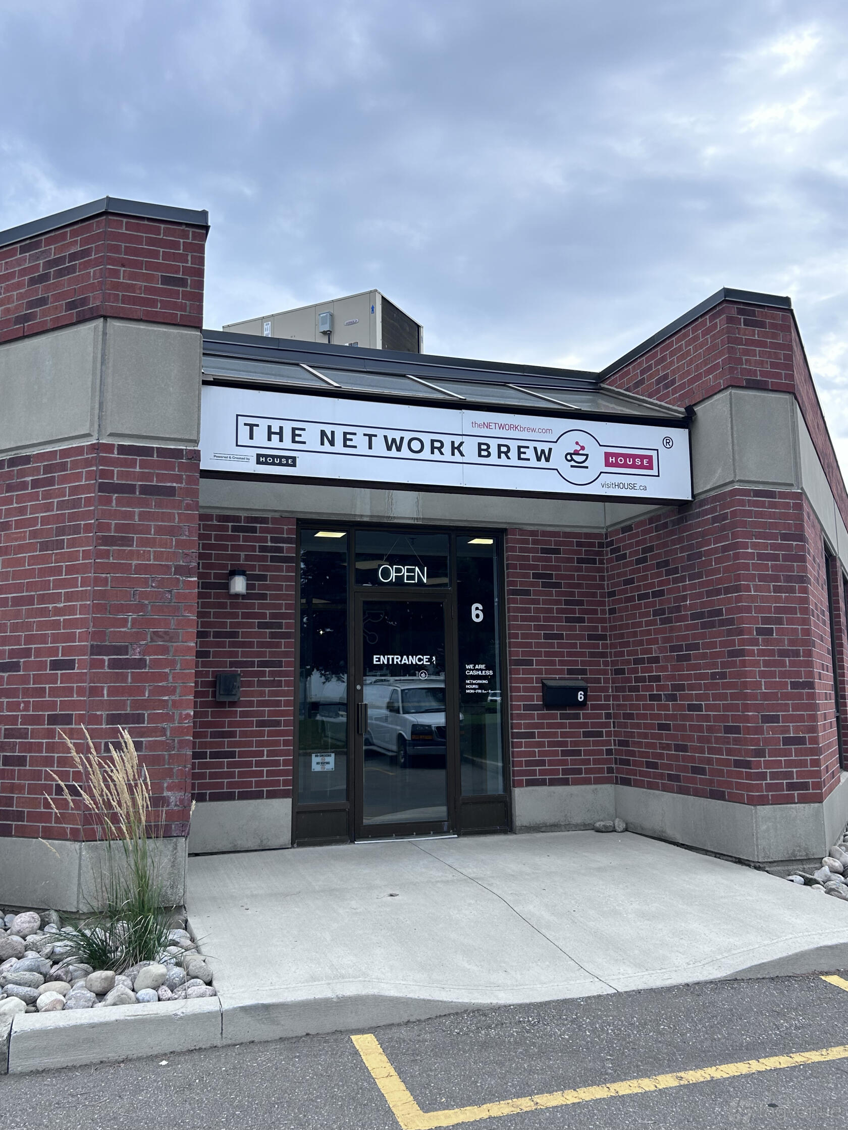 A versatile event space with a brick exterior, glass entrance doors, and venue signage at The Network Brew.