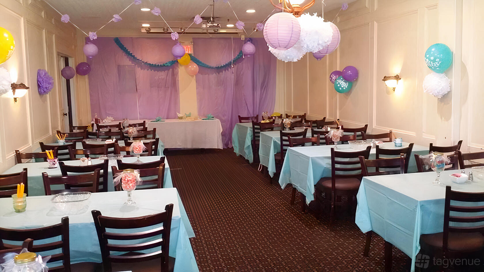 An event space with pastel decorations, hanging lanterns, and tables draped in blue linens at Sabina's Casual Dining & Pub - Pickering.