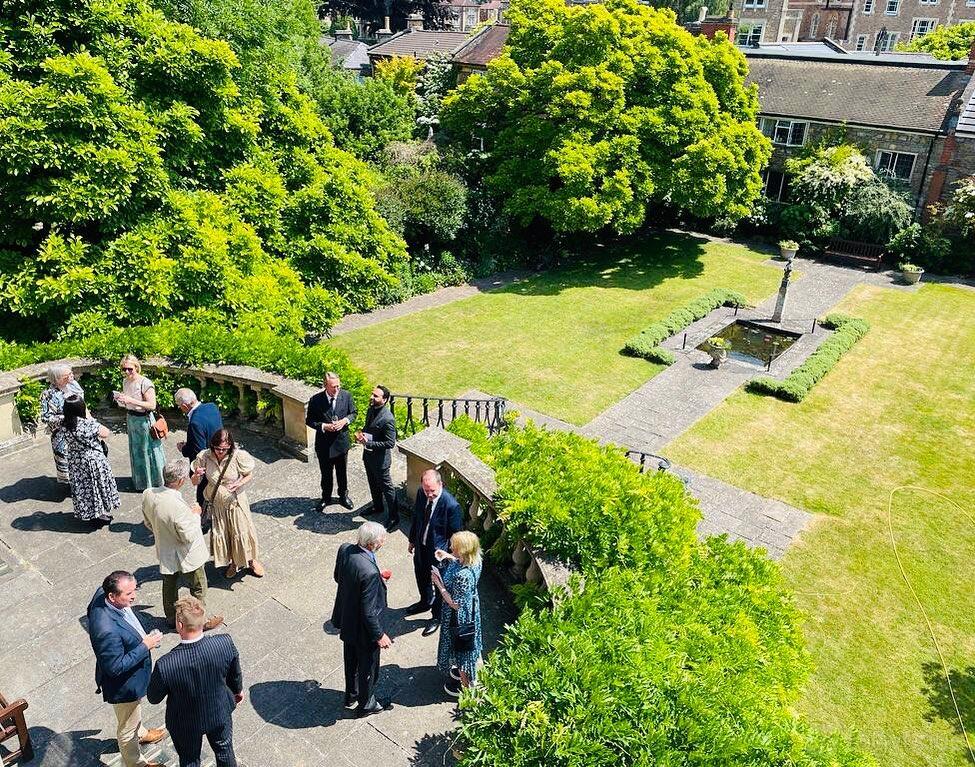 A hall with a stone terrace overlooking manicured lawns and a central fountain at Merchants' Hall.