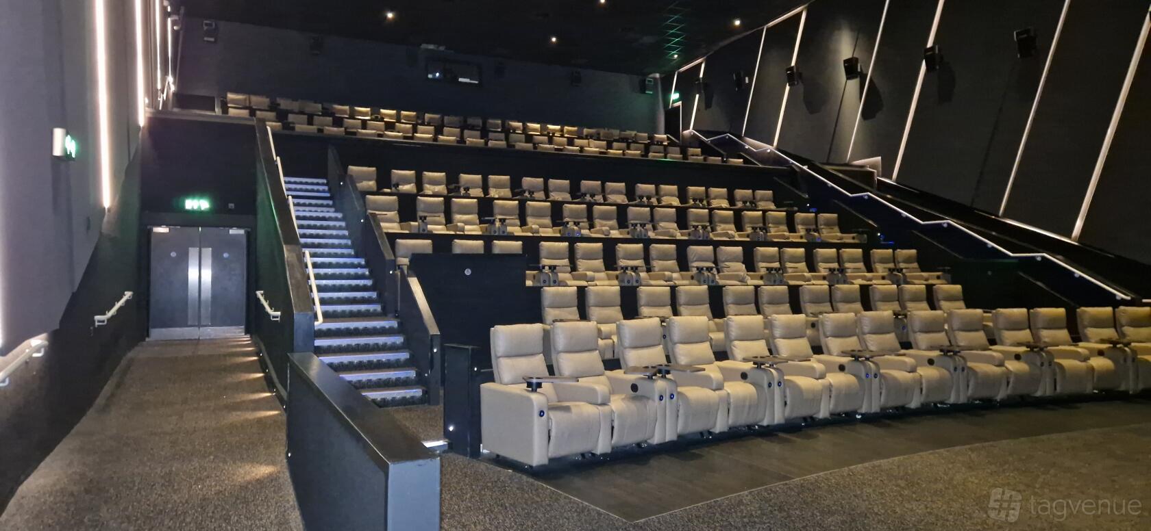 A cinema with tiered rows of plush reclining seats and aisle lighting at ODEON LUXE Birmingham Broadway Plaza.