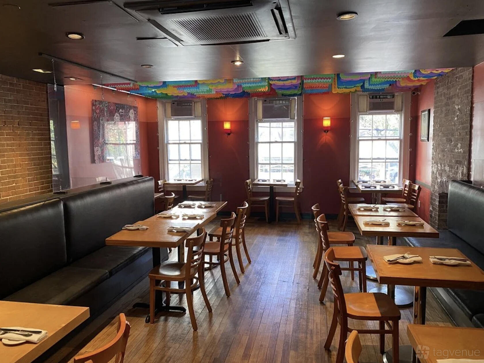 An event space in a restaurant with wood floors, colorful ceiling decorations, and large windows at Chelsea.
