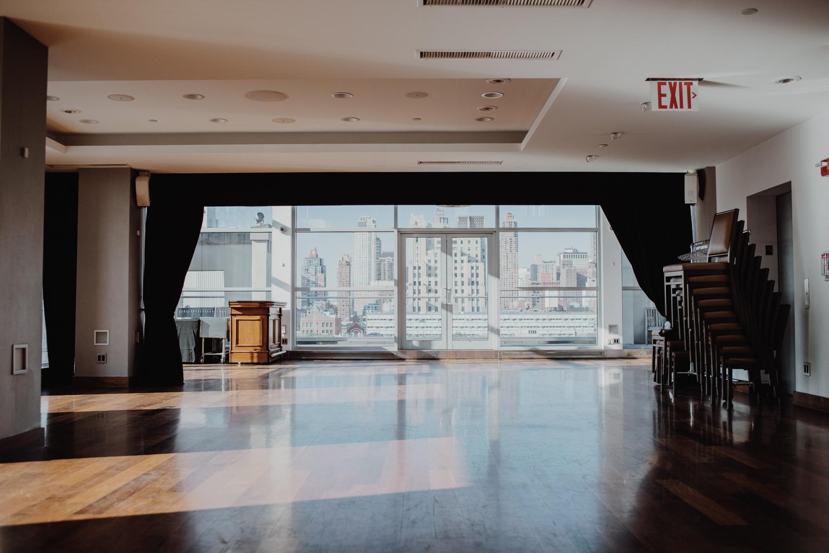 A penthouse event space with floor-to-ceiling windows, hardwood floors, and city skyline views at Penthouse 45.