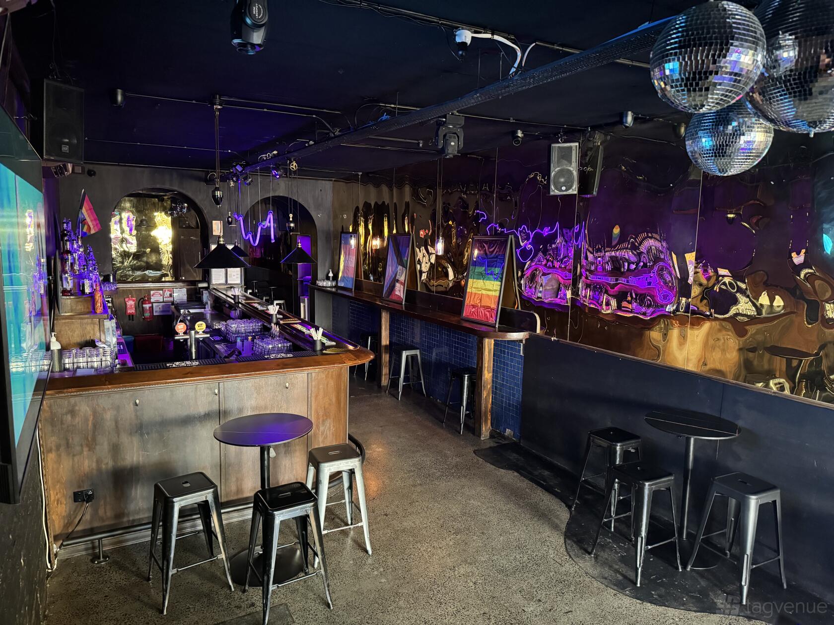 An event lounge with mirrored walls, disco balls, bar seating, and neon lighting at UBQ.