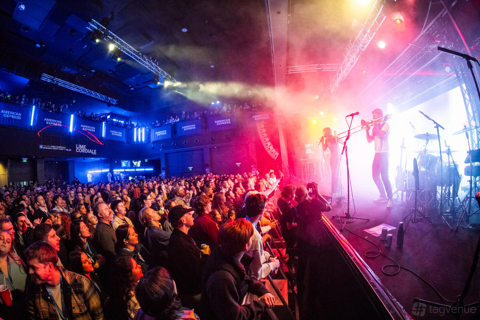 A concert hall with a large audience, stage lighting, and a live band performing at Liberty Hall.