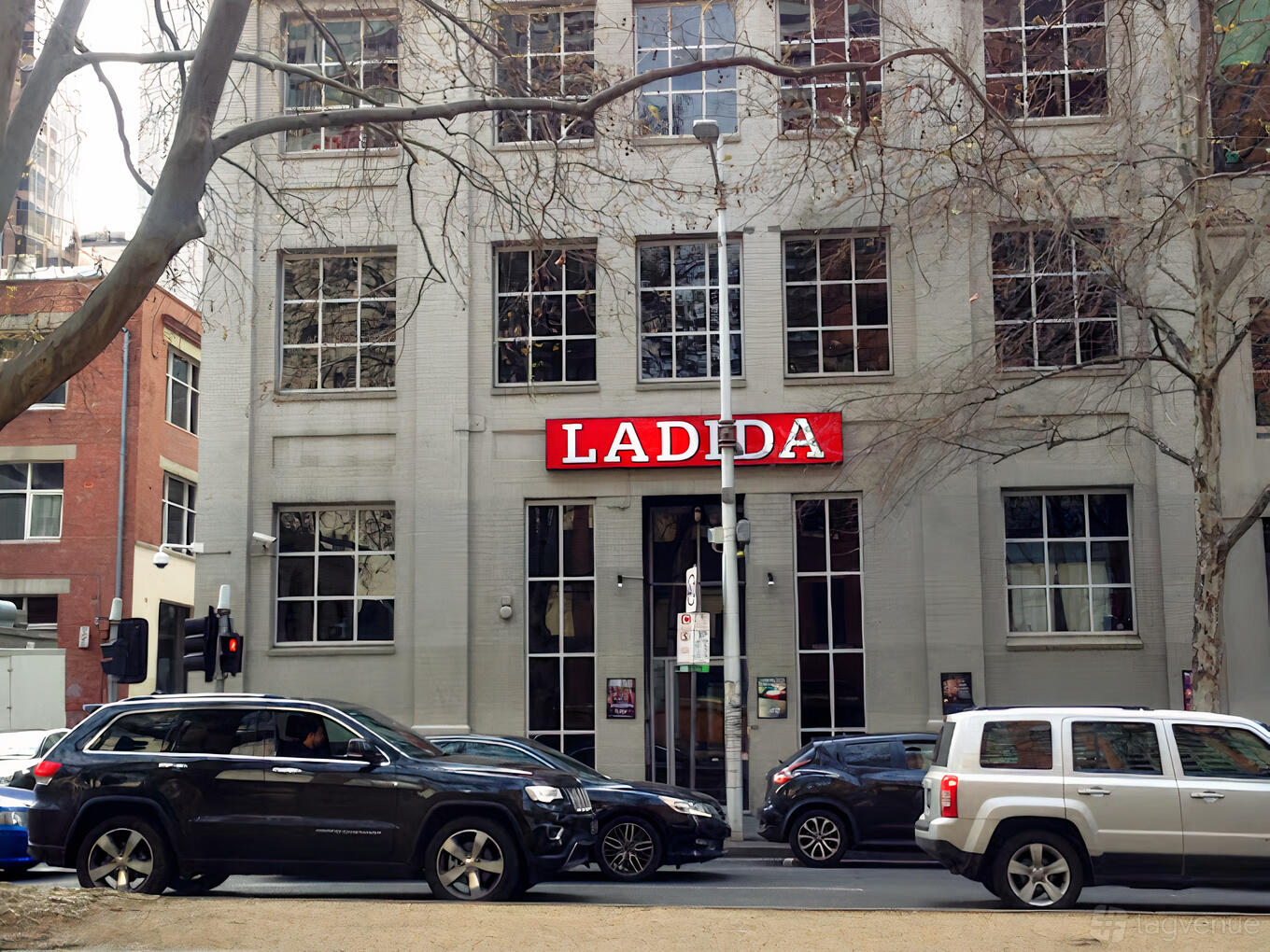 A versatile event space with a gray facade and large red sign above tall windows at La Di Da.