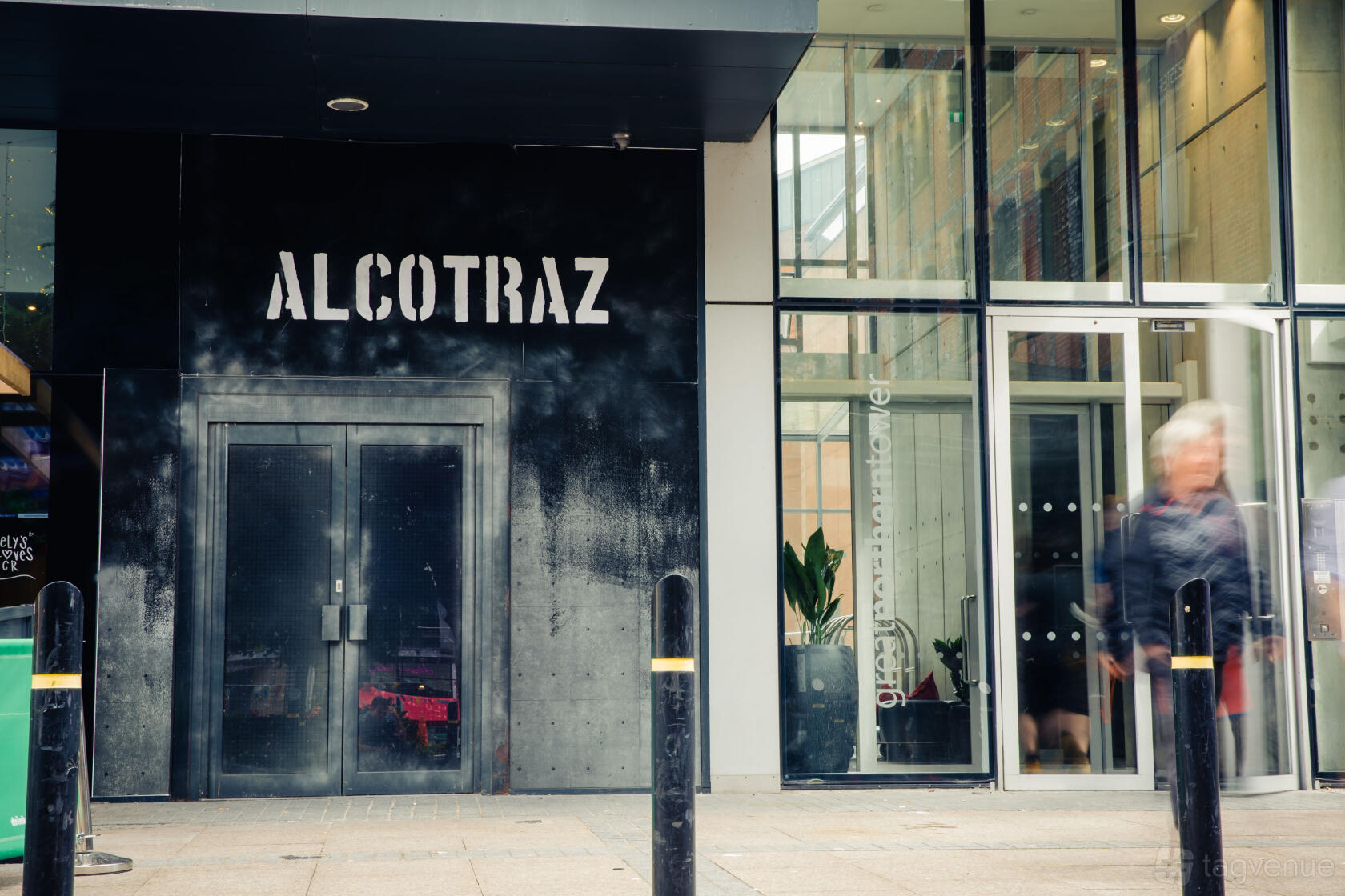 A pub entrance with double metal doors and painted black facade at Alcotraz Manchester