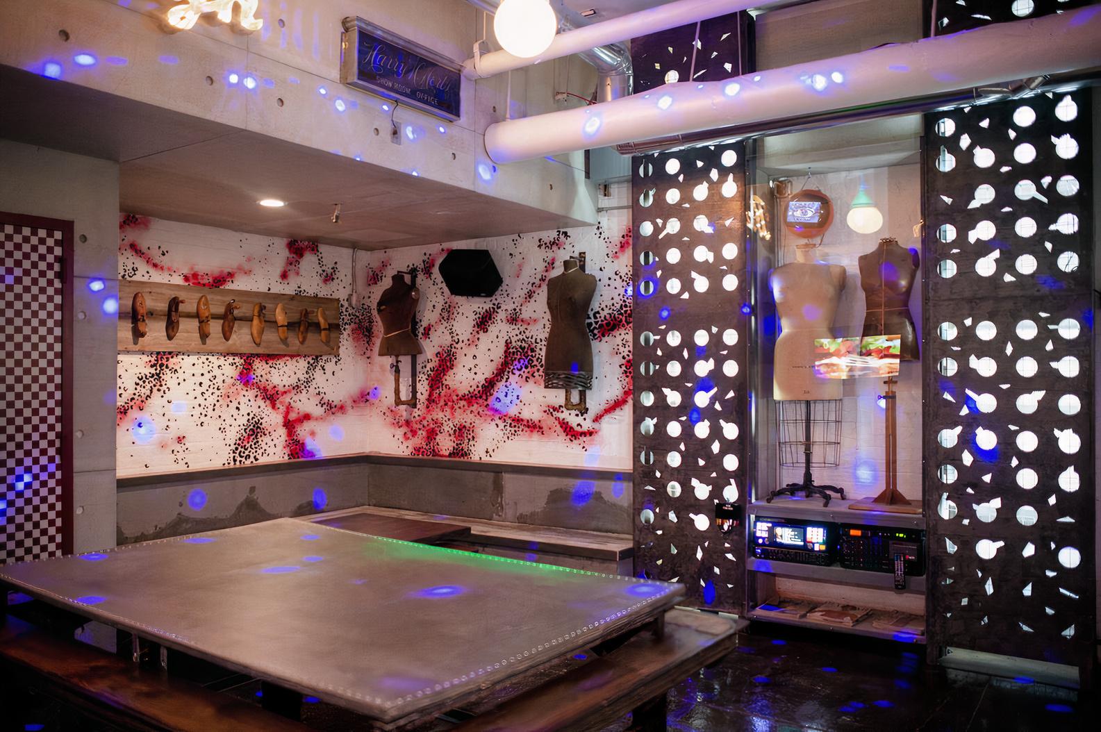 An event venue with dress form mannequins, splatter-paint wall art, and a large central table at RPM Underground.