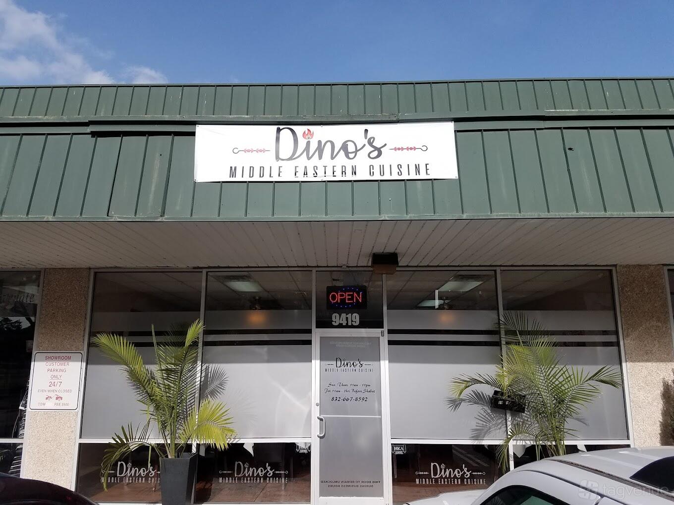 A restaurant exterior with large front windows, green awning, and potted palms at Dino's Mediterranean Cuisine.