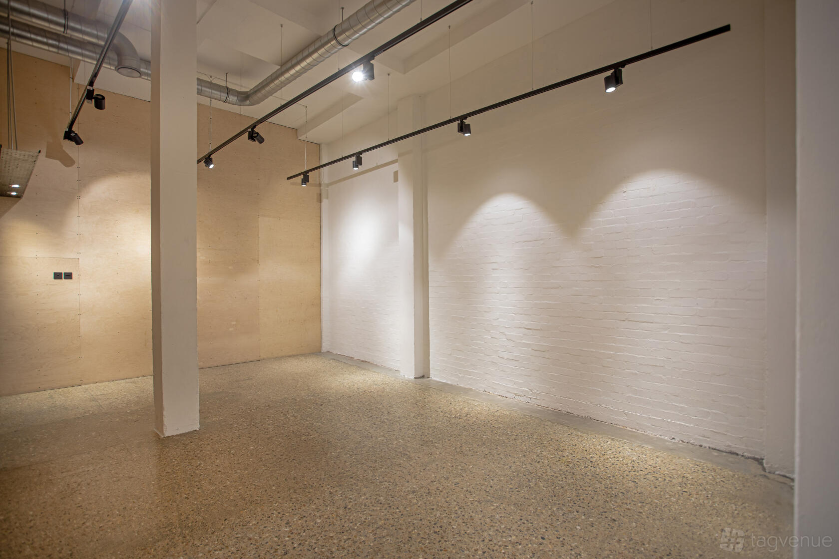 A pop up shop with polished concrete floors, exposed ductwork, and track lighting at The Factory.