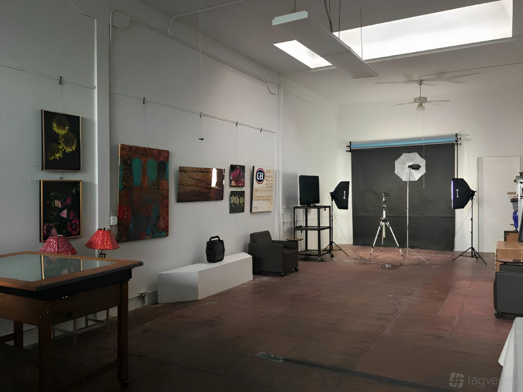 A photo and film studio with skylights, artwork on the walls, and photography lighting equipment at RBA Creative.