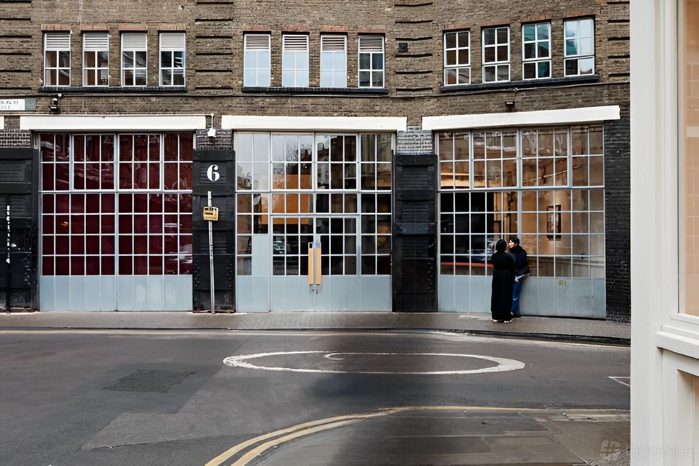 A versatile event space with floor-to-ceiling glass windows and industrial brick facade at Shoreditch Arts Club.