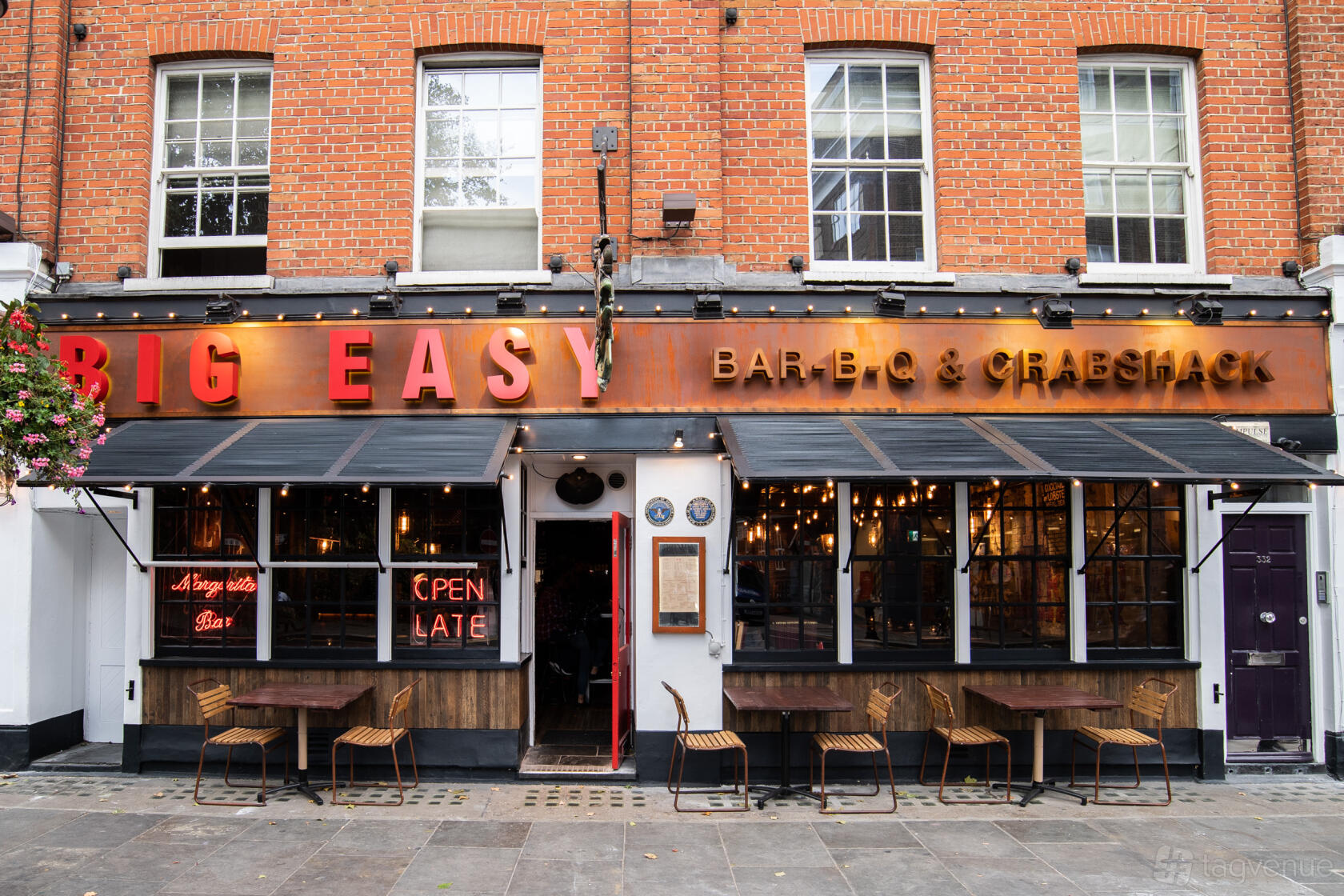 A restaurant with exposed brick facade, large front windows, and outdoor seating at Big Easy Restaurant - Kings Road, Chelsea.