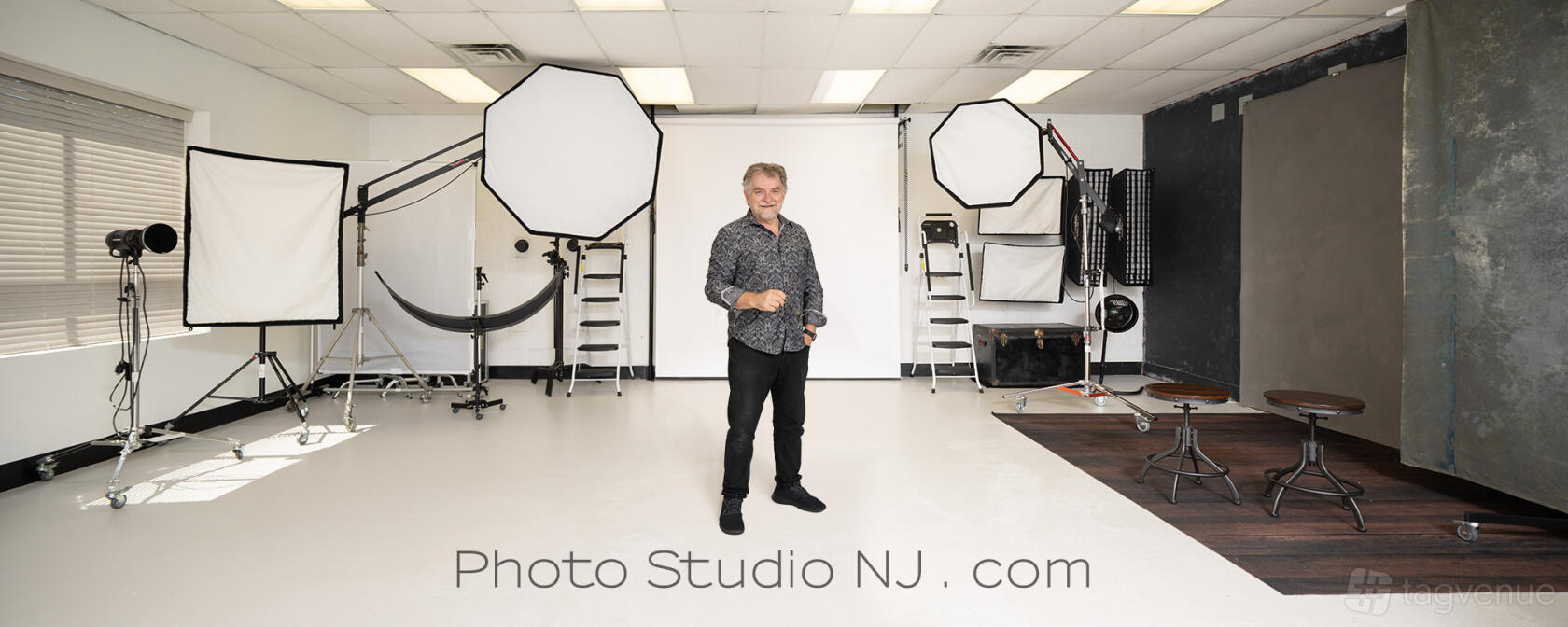 A photo studio with white cyclorama backdrop, studio lighting equipment, and softboxes at Photo Studio NJ.