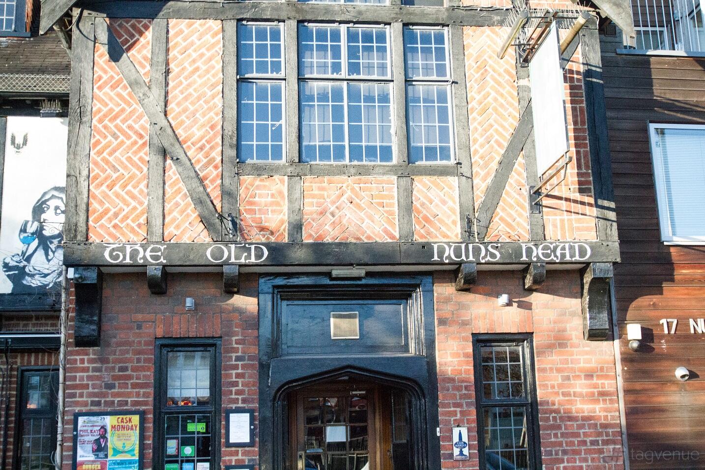 A pub with Tudor-style brickwork and timber-framed facade at The Old Nun's Head.