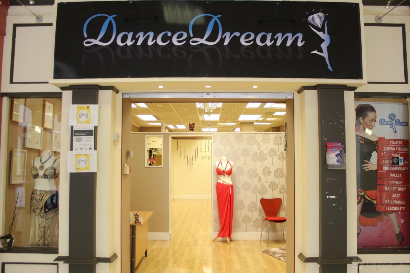 A dance studio entrance with wood floors, mirrored walls, and a mannequin in dancewear at Dance Dream Studio.