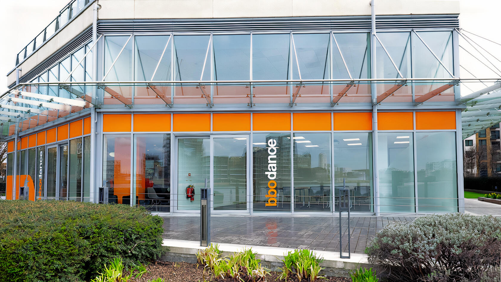 A versatile event space with floor-to-ceiling windows and orange-accented signage at bbodance.