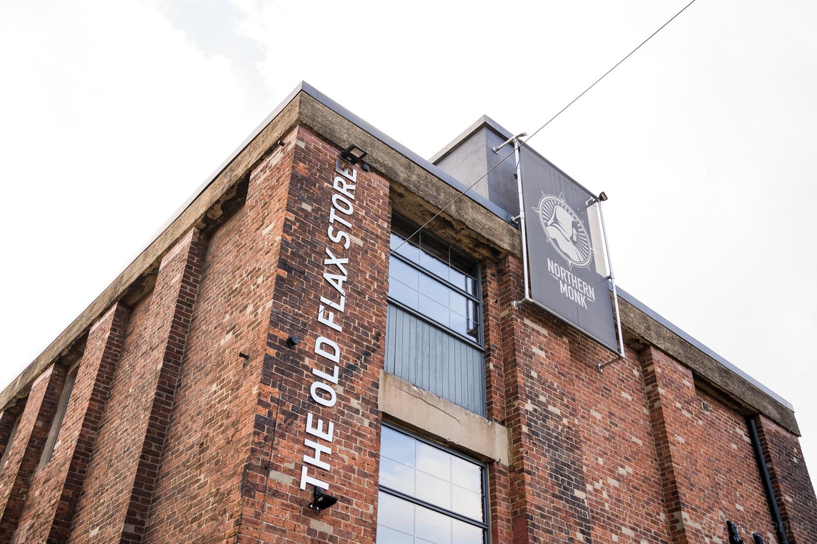 A red brick versatile event space with large windows and external signage reading 'The Old Flax Store' at The Chapter Hall.