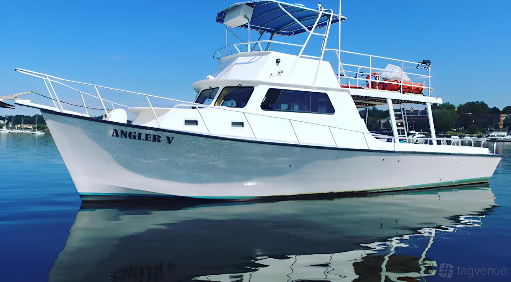 A boat venue with white exterior, upper deck seating, and covered helm at The Angler Fleet.