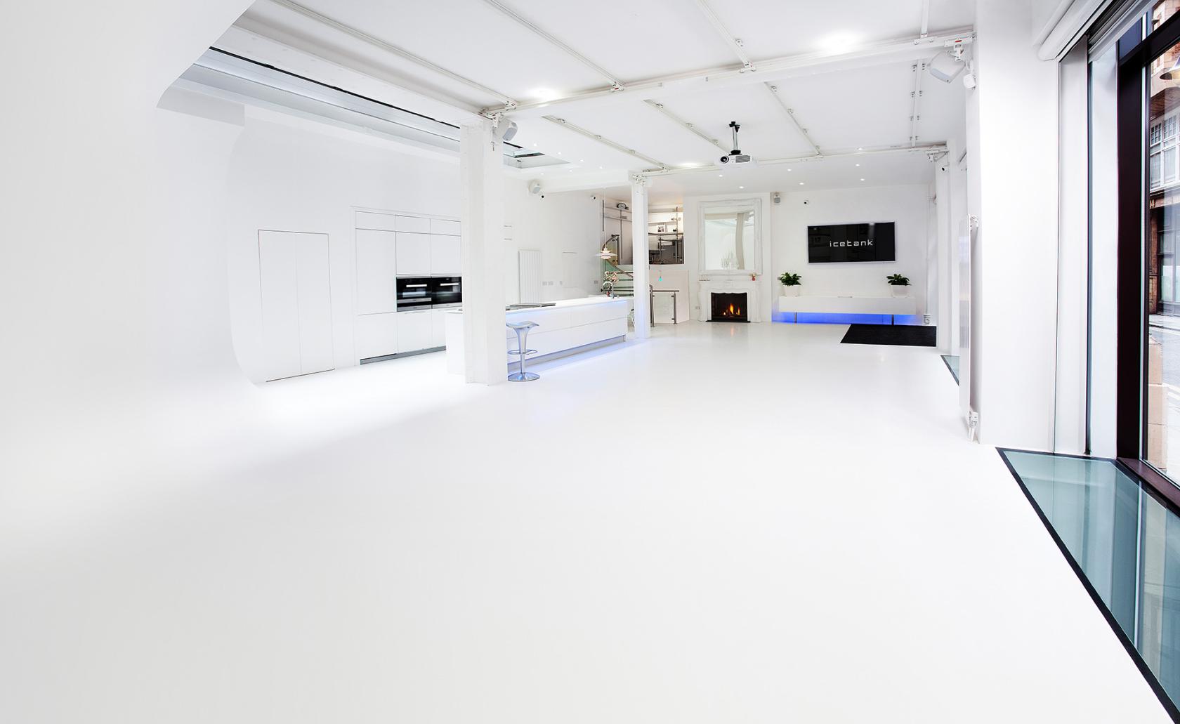 An event venue with white floors, white walls, a wall-mounted screen, and modern lighting at Icetank Venue.