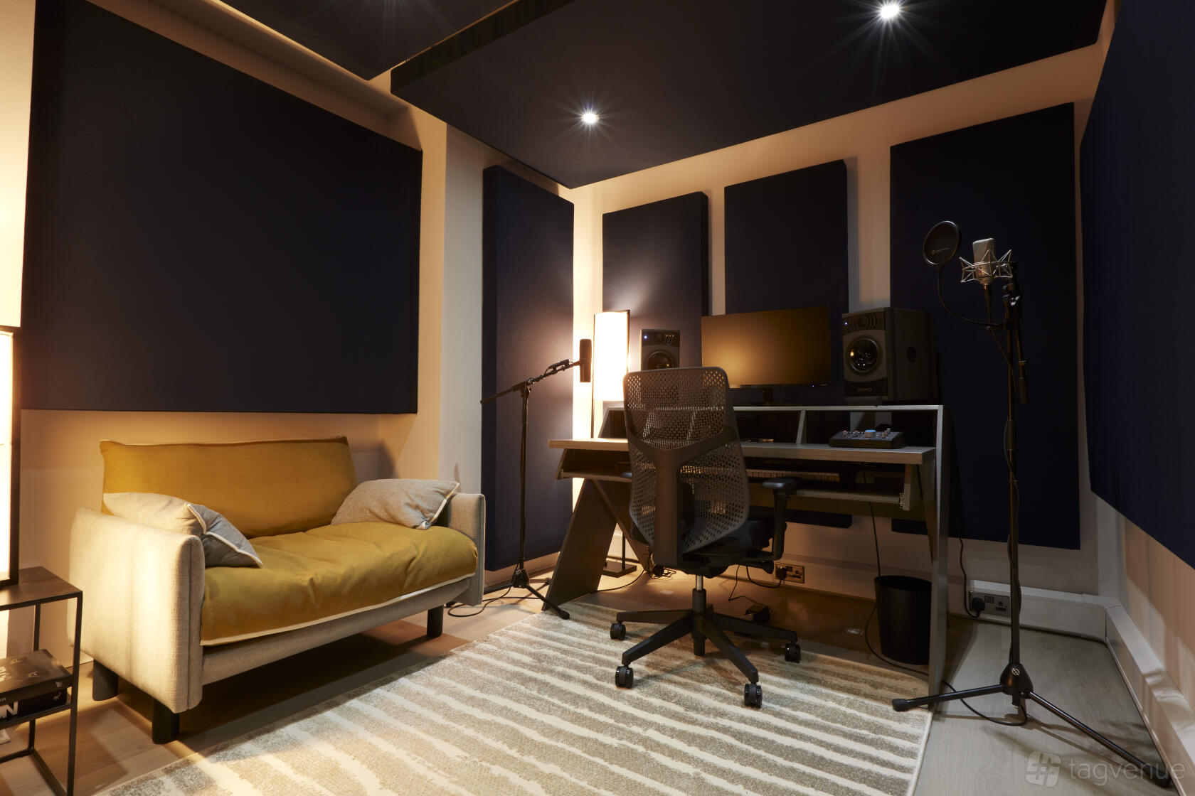 An event venue with soundproofed walls, a recording setup, and a yellow sofa at Qube Hackney - House Party Venue.
