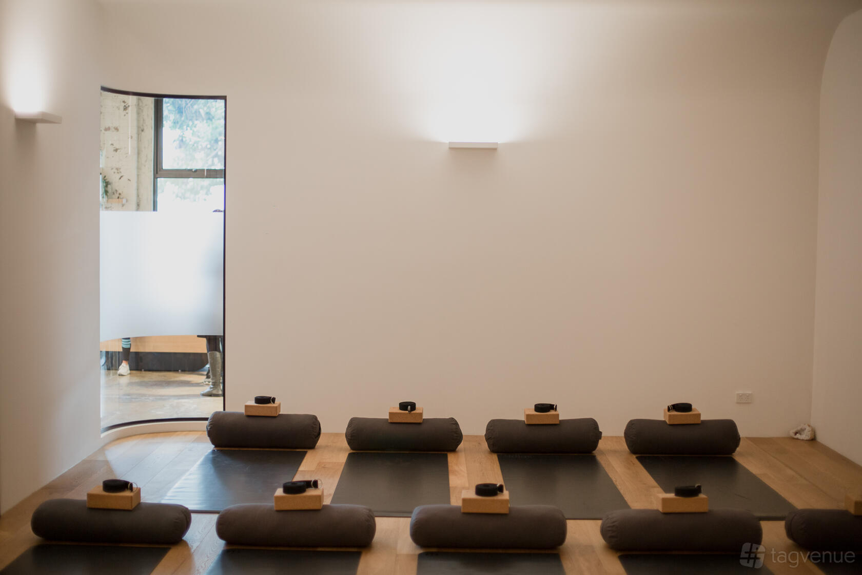 A film studio with yoga mats, bolsters, and cork blocks on wooden floors at Selph Health Studios.