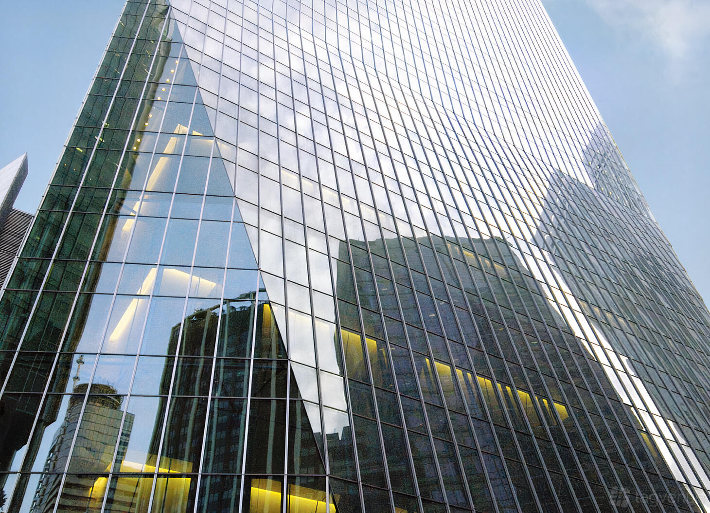 A glass skyscraper facade with mirrored windows reflecting surrounding buildings at One Raffles Quay.
