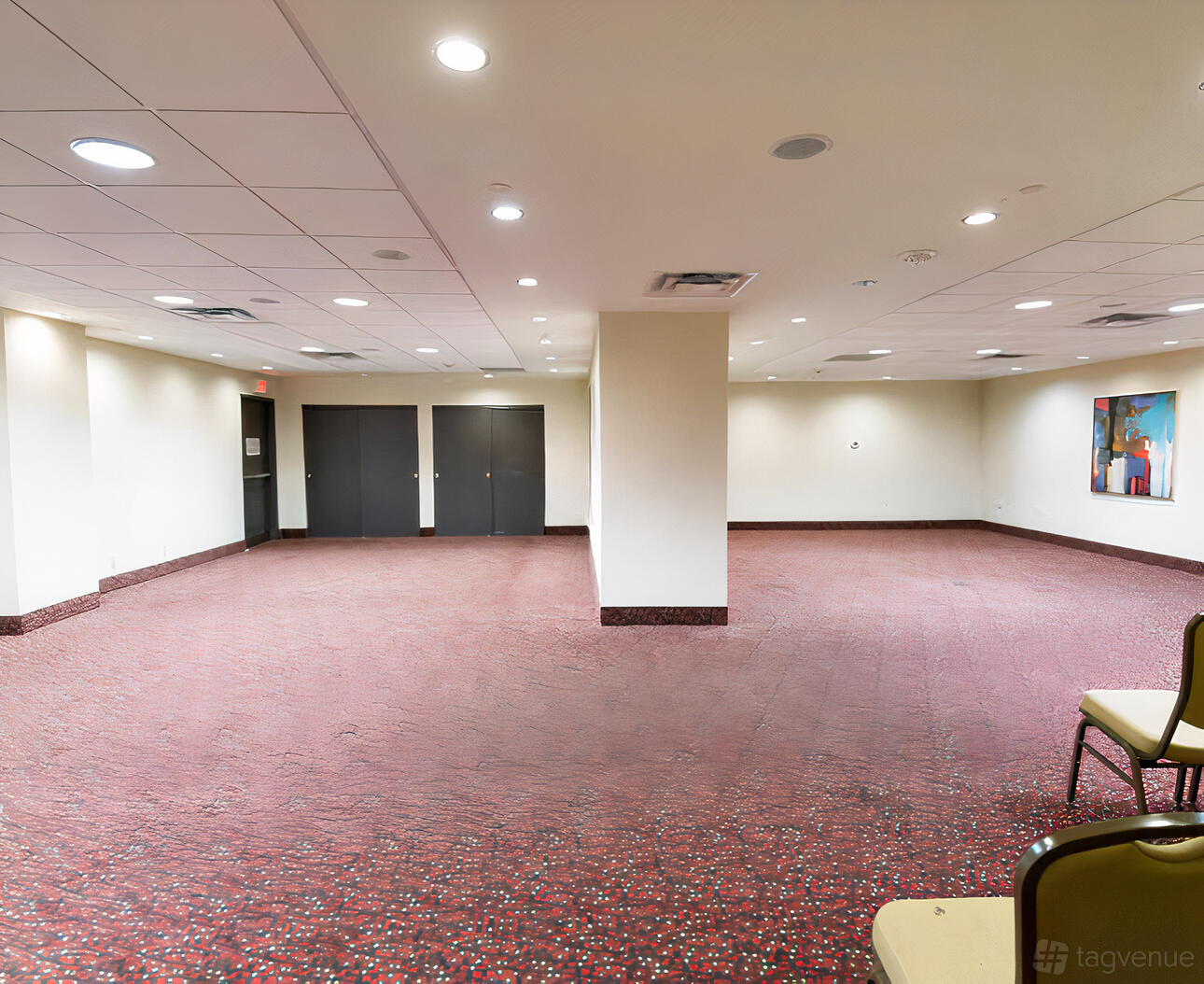 A meeting room with recessed lighting, neutral walls, and red patterned carpet at Holiday Inn Toronto Downtown Centre.