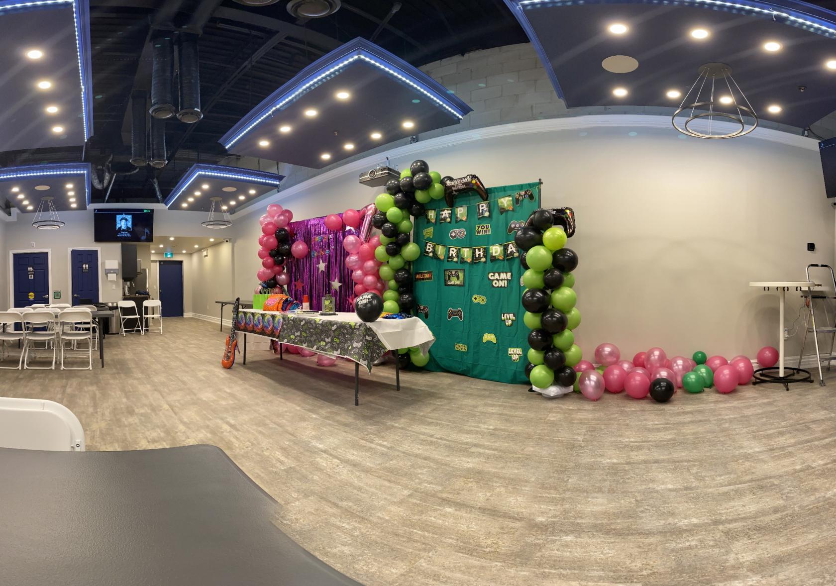 An event venue with wood-look flooring, LED ceiling lights, and balloon decorations at York Studios Event Space & Gallery.