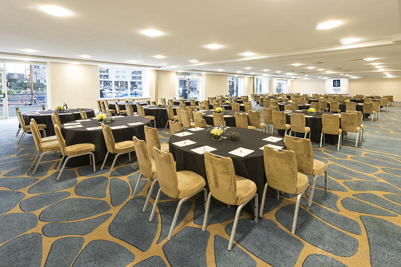 An event space with round tables, gold chairs, and patterned carpet at Chelsea Harbour Hotel & Spa.