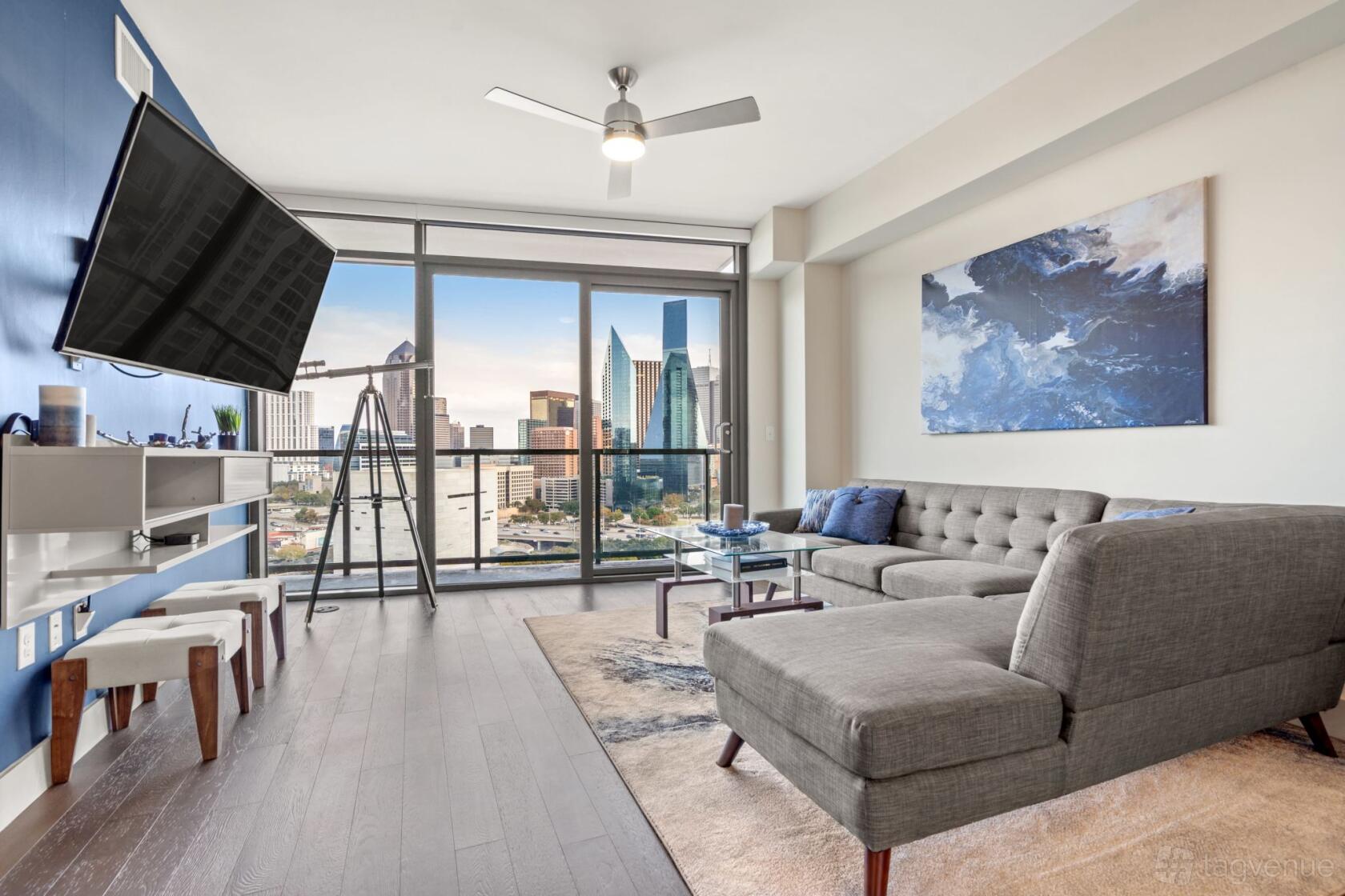 An event venue with a lounge area, floor-to-ceiling windows, city skyline view, sectional sofa, and modern decor at Apex Genesis.